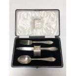 A cased silver knife, fork and spoon, napkin ring.