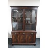 A mahogany double door bookcase fitted with three cupboards