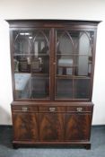 A mahogany double door bookcase fitted with three cupboards