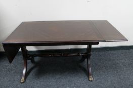 A reproduction mahogany flap sided low table