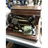 A cased vintage Singer hand sewing machine