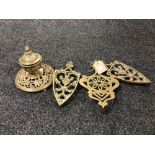 An ornate brass lidded inkwell together with three antique trivets