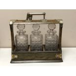 An Edwardian oak and silver plate mounted three bottle Tantalus CONDITION REPORT: