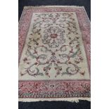 A floral woollen rug on cream/pink ground,