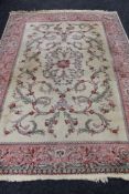 A floral woollen rug on cream/pink ground,