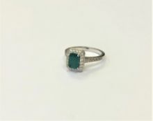 An 18ct white gold emerald and diamond cluster ring, size M1/2. CONDITION REPORT: 4.