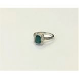 An 18ct white gold emerald and diamond cluster ring, size M1/2. CONDITION REPORT: 4.