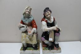 A pair of antique Staffordshire glazed pottery figures a/f