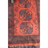 An Afghan Bokhara rug on red ground,