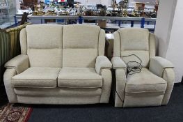 A two seater settee in oatmeal covering together with the matching electric reclining armchair