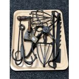 A tray of antique metal ware, cast iron tongs, trivets,