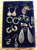 Nine pairs of silver earrings.