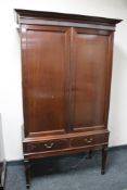 A mahogany double door cabinet on stand fitted with two drawers