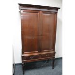 A mahogany double door cabinet on stand fitted with two drawers