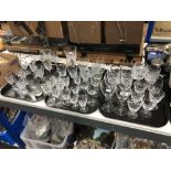 Three trays of twentieth century cut glass, wine glasses, champagne flutes,