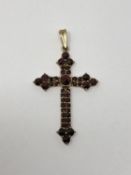 A yellow gold cross set with garnets, 4.24g.