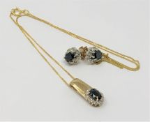 A sapphire and diamond pendant in yellow gold with matching earrings.