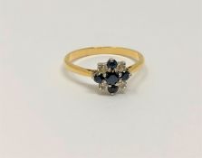 An 18ct gold platinum set sapphire and diamond cluster ring, size P, 2.9g.