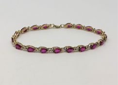 A gold bracelet set with red stones and small diamonds, 7g.