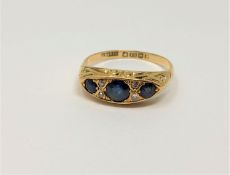 An 18ct gold three stone sapphire and diamond ring, size P, 3.6g.