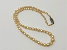 An 18 inch strand of pearls on gold and diamond clasp