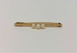 A 9ct gold bar brooch set with three pearls, 1.6g.