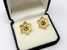 A pair of gold sapphire floral earrings, diameter approximately 8mm.