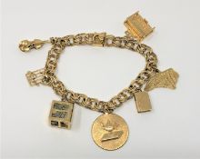 A 14ct gold bracelet mounted with yellow metal charms, most stamped 14k, 38.2g.