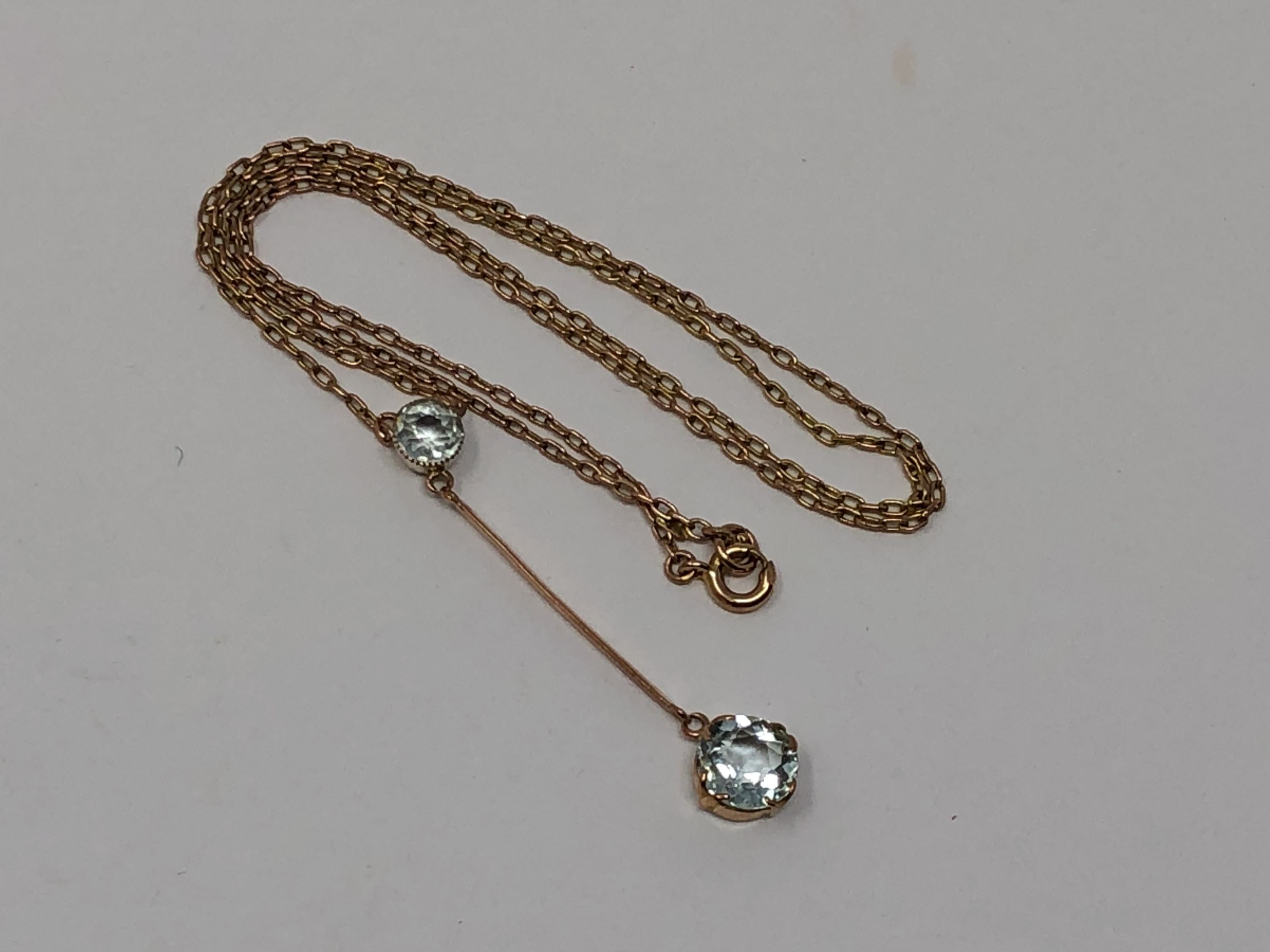 An antique gold two stone aquamarine pendant on gold chain
