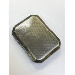 A silver cigarette case with engine turned decoration,