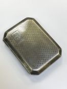 A silver cigarette case with engine turned decoration,