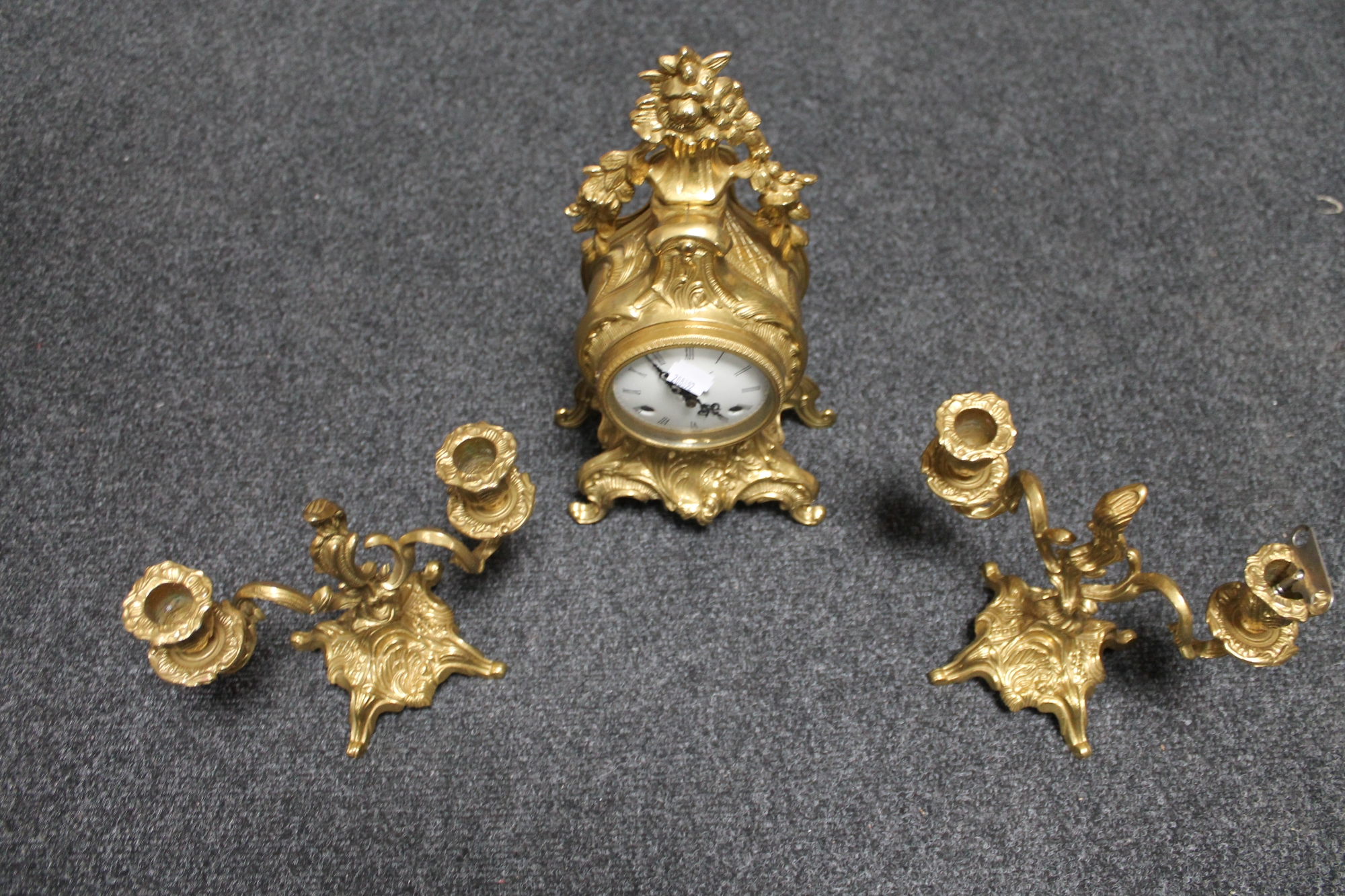 A heavy cast brass three piece clock garniture