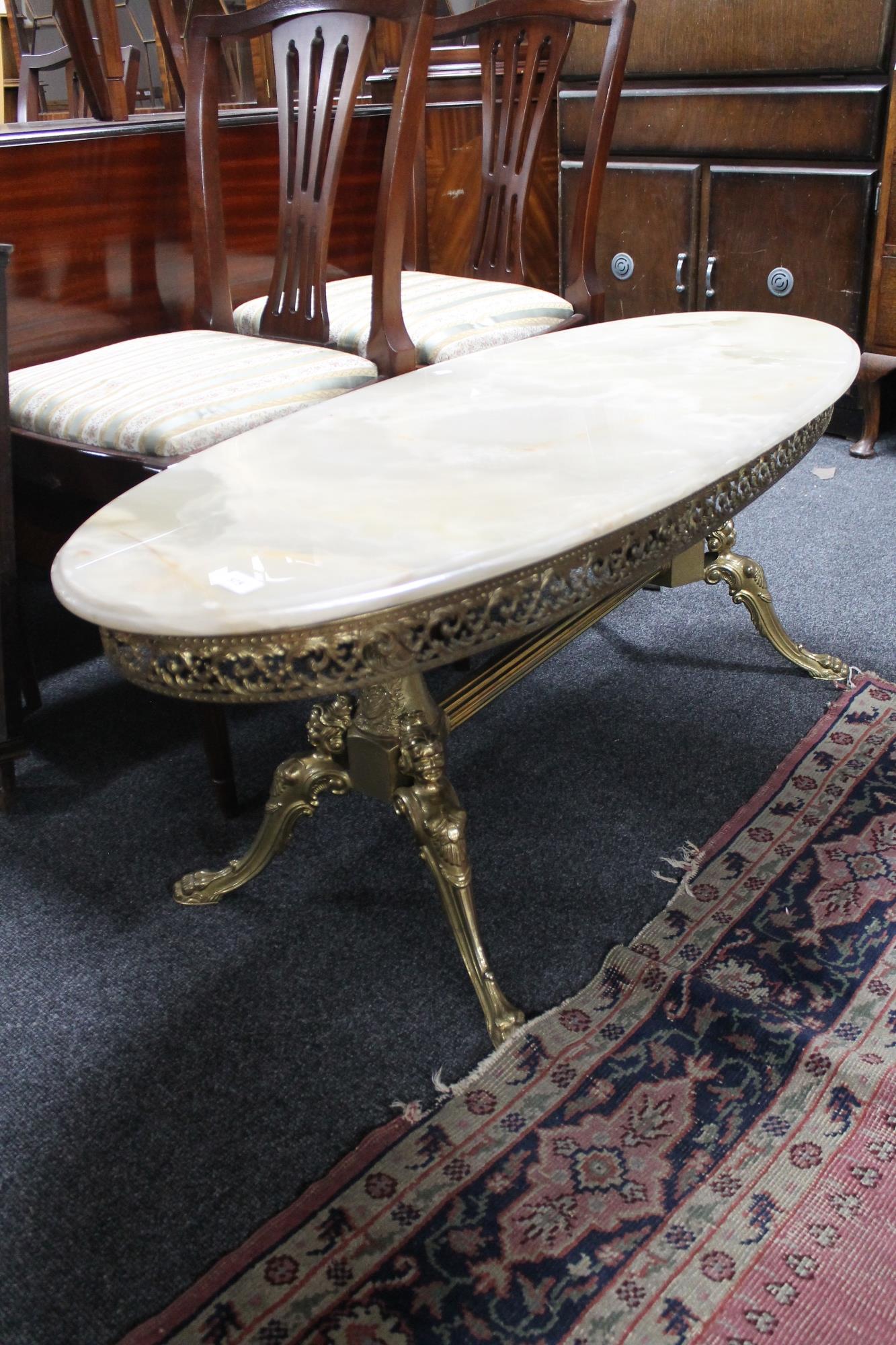 An onyx and brass based oval coffee table