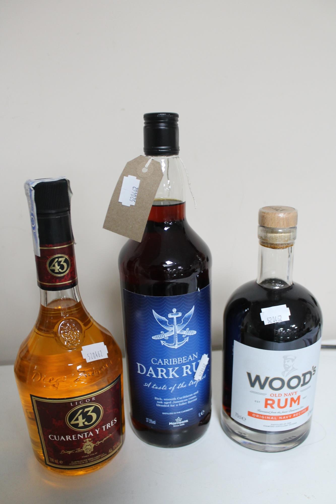 Three bottles of alcohol - Woods Old navy rum 70cl, Cuarenta Y Tres 700ml and Caribbean dark rum 1l.