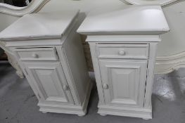 A pair of white bedside cabinets
