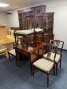 A reproduction inlaid mahogany flap sided dining room table and six chairs