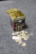 A metal tin of pre decimal British coins and foreign coins