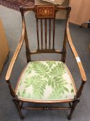 An Edwardian inlaid mahogany elbow chair, with green leaf upholstery.