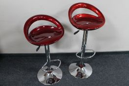 A pair of contemporary gas lift bar stools together with a small lamp table