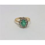 A 14ct yellow gold emerald and diamond cluster ring, the medium green emerald 7.