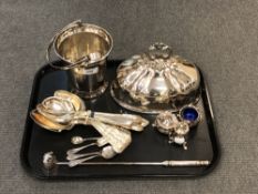 A tray of silver plated wares including food cover, three piece cruet, table spoons, bucket,