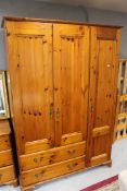 A pine triple door wardrobe fitted two drawers