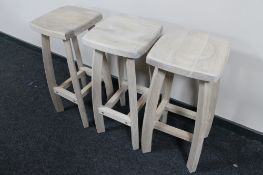 A set of three light oak bar stools