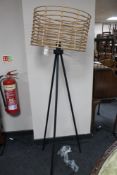 A reproduction floor lamp with wire and wicker work shade