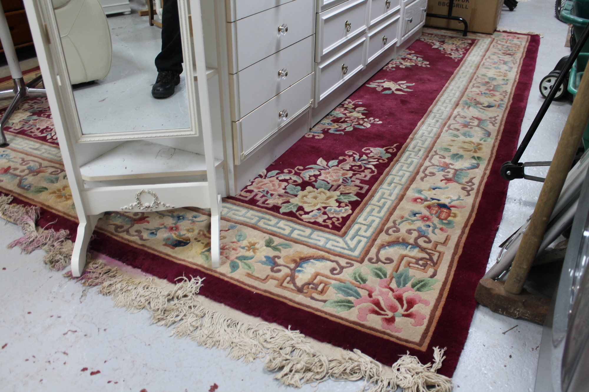 A large fringed Chinese carpet on red ground,