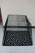 A large metal dog cage with black and white fabric interior