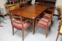 A mid century extending dining room table together with six armchairs