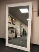 A large contemporary white gloss floor standing mirror