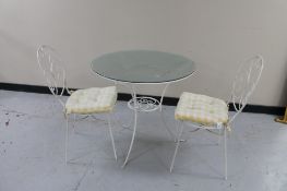 A metal and glass topped patio table and two chairs