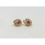 A pair of 18ct gold diamond and ruby earrings.